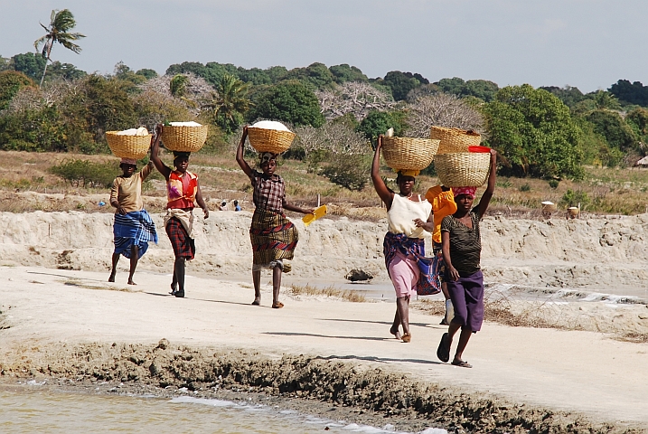Frauen tragen Körbe voller gewonnenem Salz zum Lager