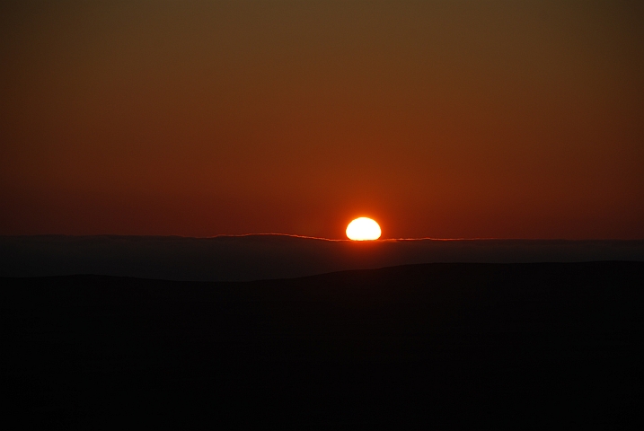 Die Sonne versinkt hinter der Skelettküstenbewölkung