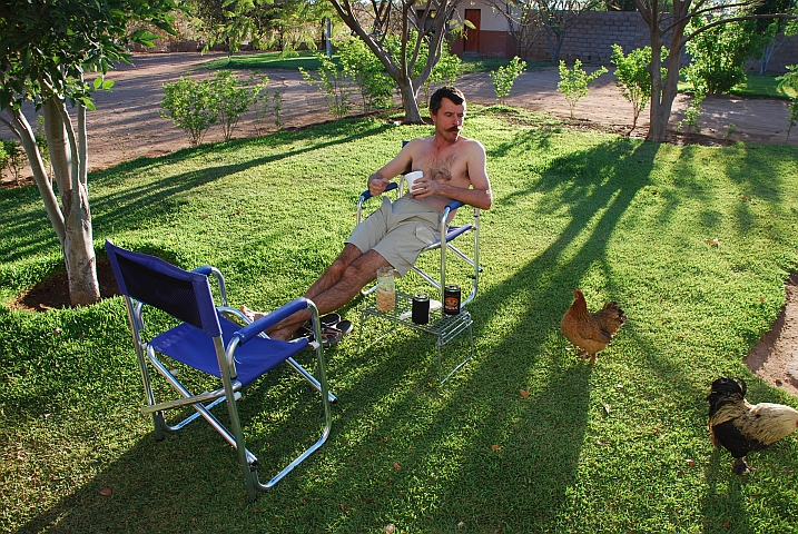 Thomas liegt gemütlich im Stuhl auf dem grünen Wiesli des Camps