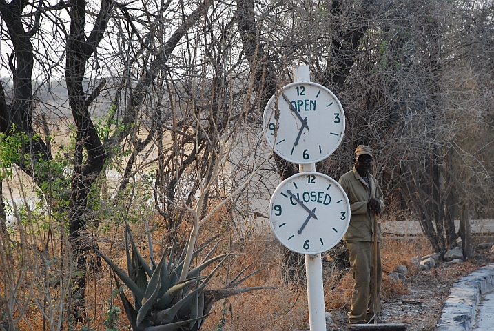 Angestellter mit den Öffnungszeiten-Uhren