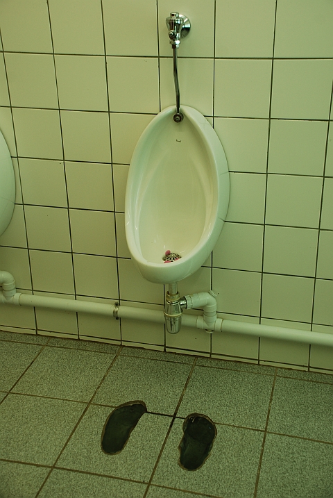 Pissoir mit gläserner Fussmarkierung