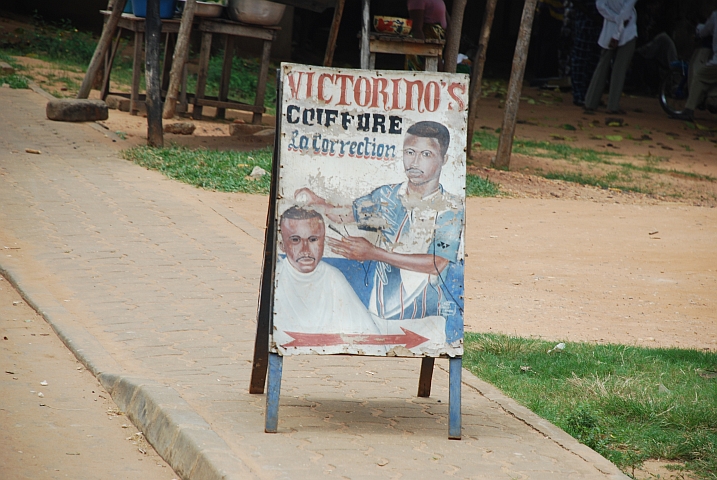 Werbetafel des Coiffeurladen “La Correction“ mit Meister Victorino’s Konterfei;: Da macht der Meister wohl persönlich die Korrektur?!?