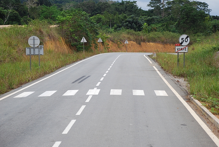 Un-afrikanische Strasse vom Belag, über die Beschilderung bis zur Markierungen samt Fussgängerstreifen