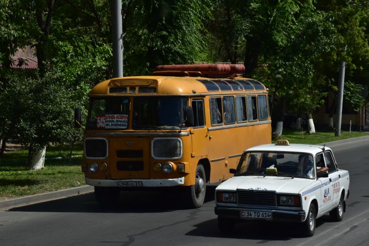 Gasgetriebener Bus (Gastanks auf dem Dach) und Lada-Taxi in Jerewan