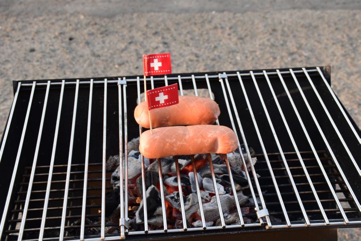 Cervelats mit Schweizer Fähnchen auf dem Grill