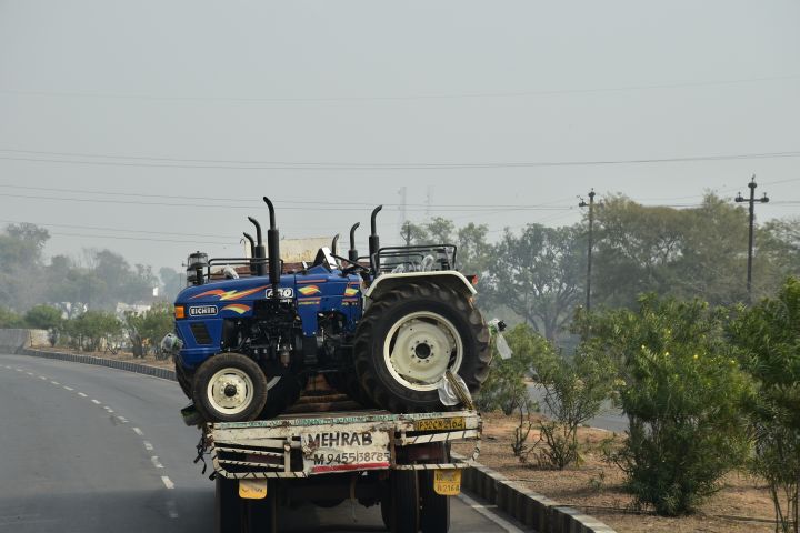 Fabrikneue Traktoren quer auf der Ladefläche des Lastwagens