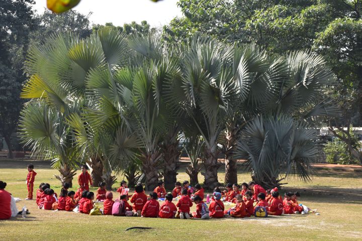 Knirpse in roter Schuluniform auf Schulausflug im Nehru Park in Neu-Delhi