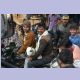 Lachende Gesichter von zwei Männern mit einer Ziege auf einem Motorrad im Verkehrschaos von Agra