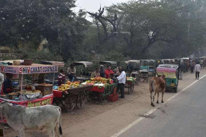 Fliegende Händler und Rikschafahrer warten beim Parkeingang auf Kundschaft