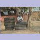 Älterer Mann sitzt gemütlich auf einem Reifenstapel in der Nähe von Kolkata
