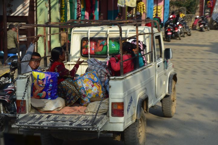 Vier Personen auf der Ladebrücke eines Nepalesisches Gebirgs-Taxis in Waling