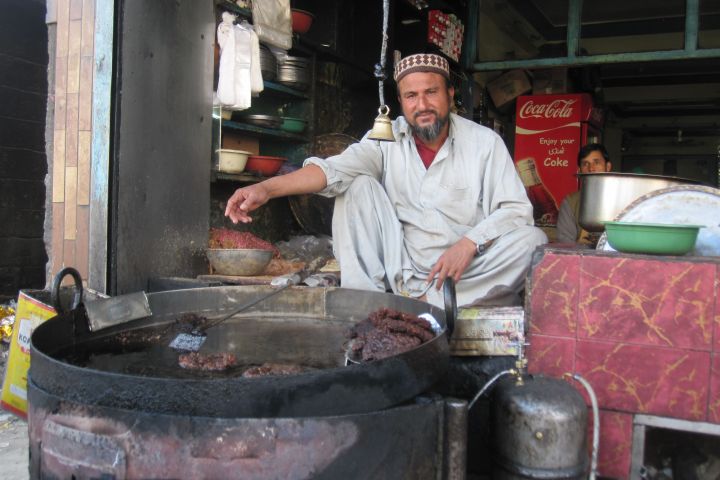 Garküche mit dem Koch vor einem grossen Brattopf