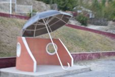 Bushaltestelle mit überdimensionalem Regenschirm als Dach